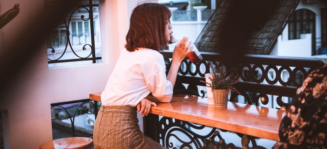 Woman at a bar drinking through a straw